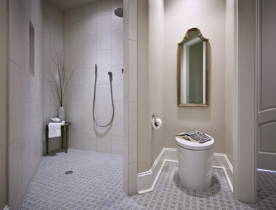 Tan shower with tile floor and wall. Modern toilet with tile floor